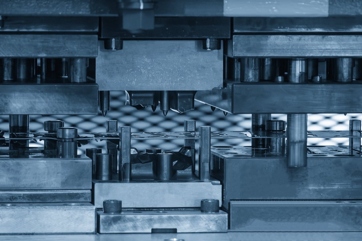 Sheet metal being formed by a progressive die stamping press